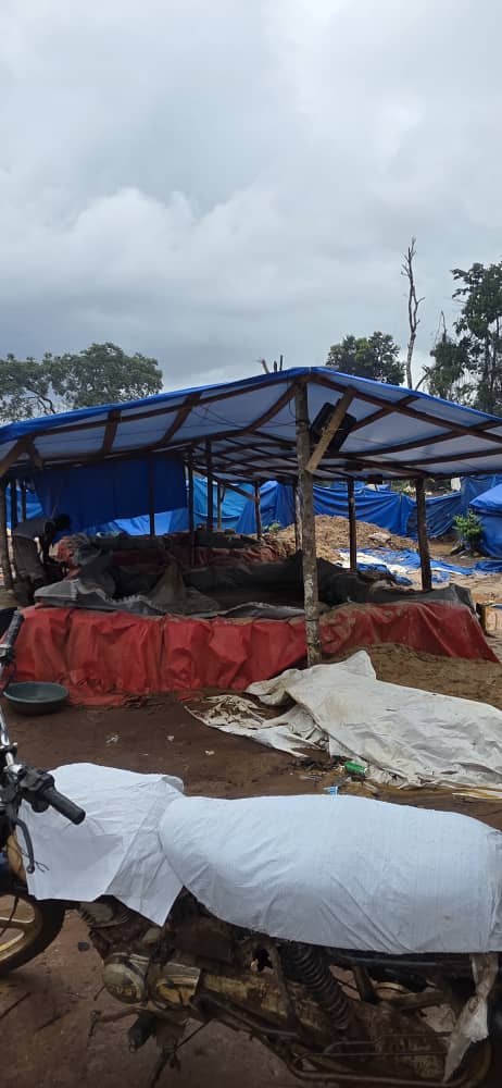 Tarpaulin shelters and covered loads across the camp.
